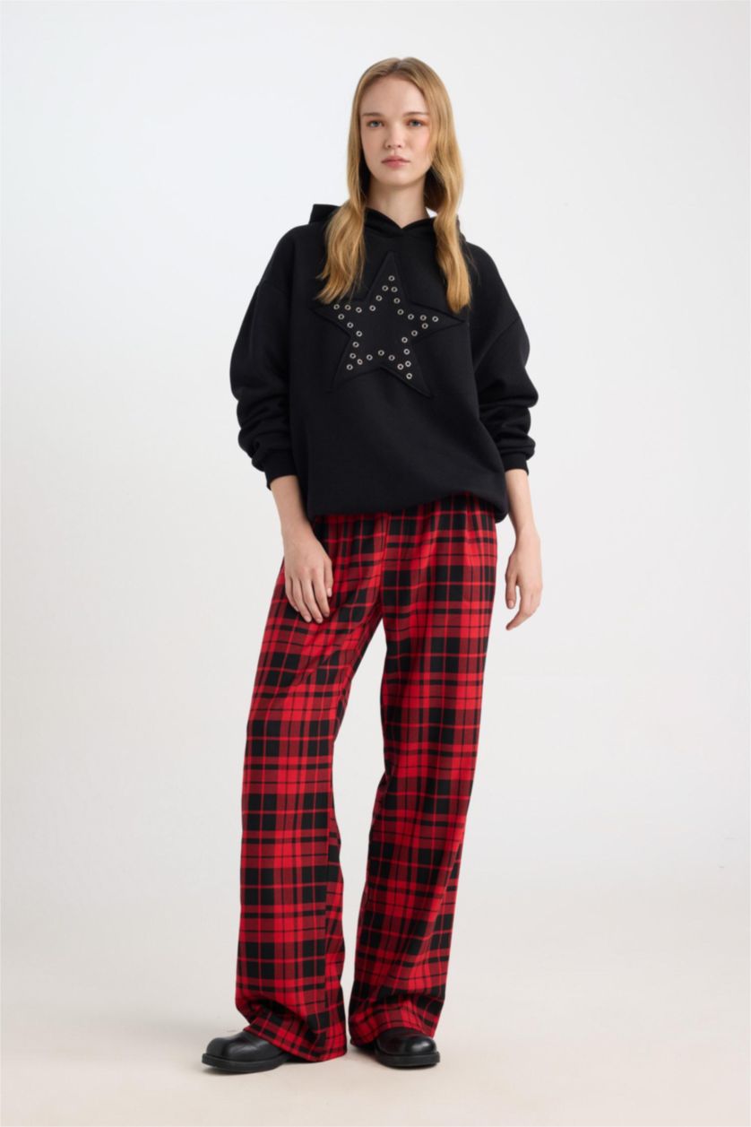 Buffalo plaid pants styled with a black sweatshirt, full length view